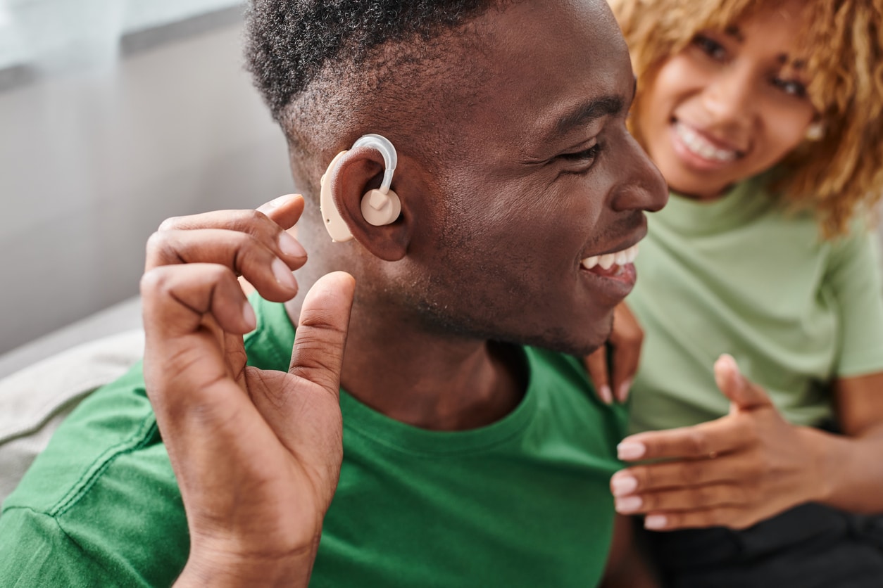 Man trying on his new hearing aid with his girlfriend.