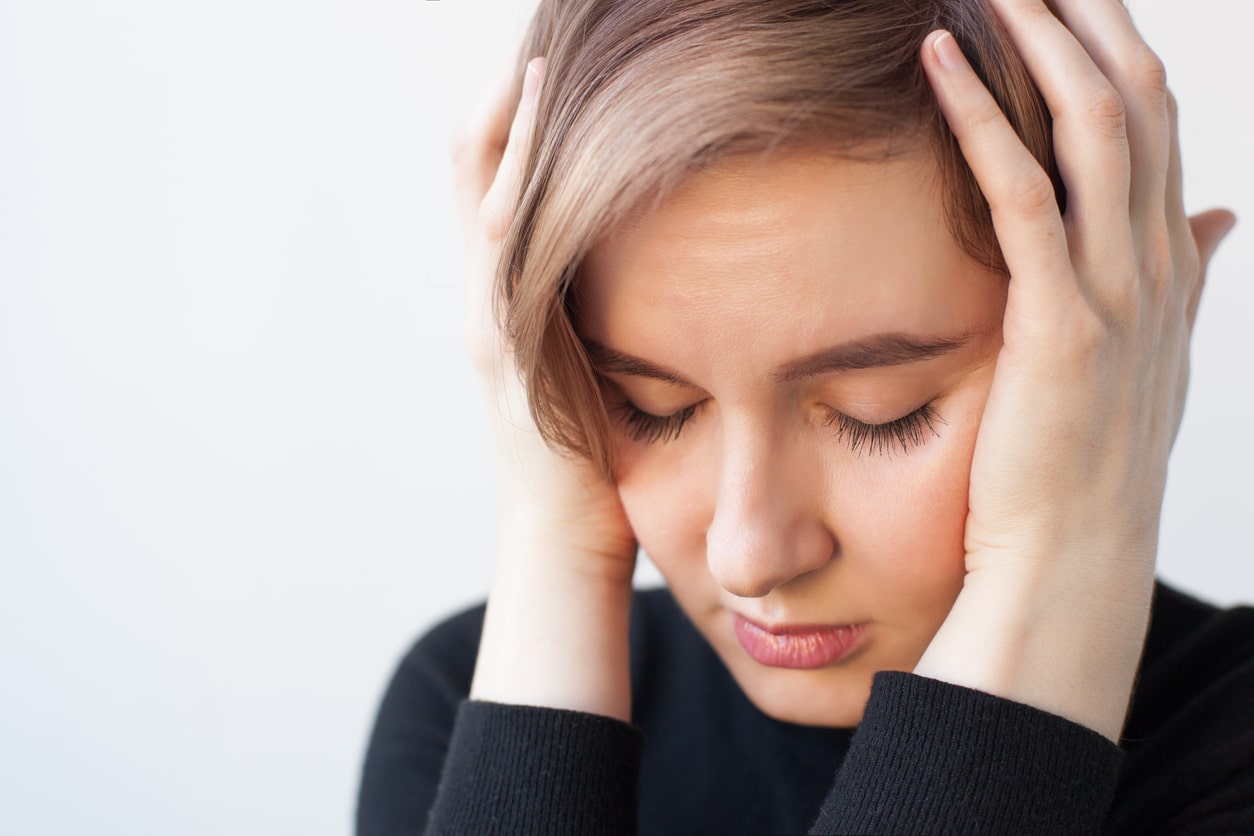 Girl with her eyes closed and hands over her ears
