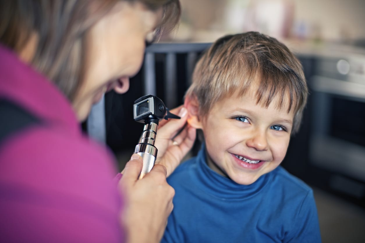 Happy little boy having home visit ear exam