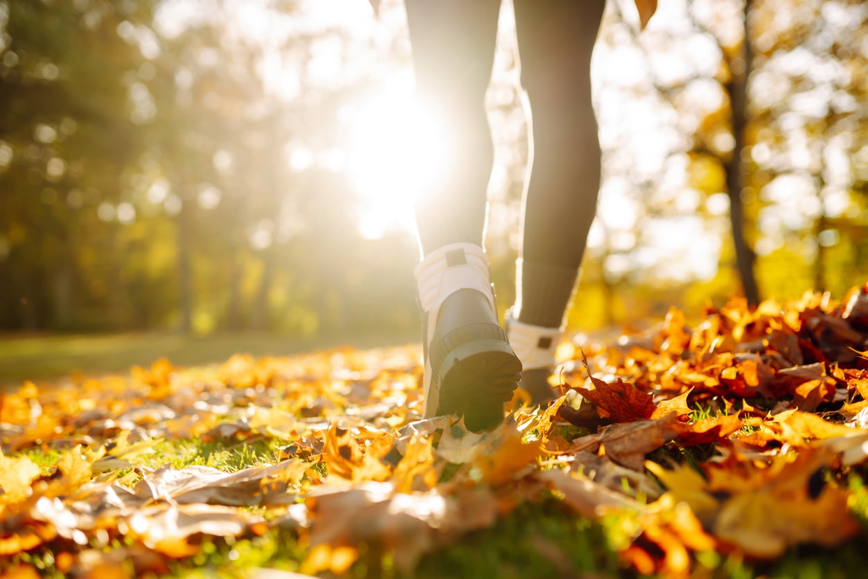 Shot of someone in hiking boots walking on a fall trail