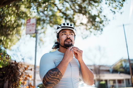 Cyclist putting his helmet on.